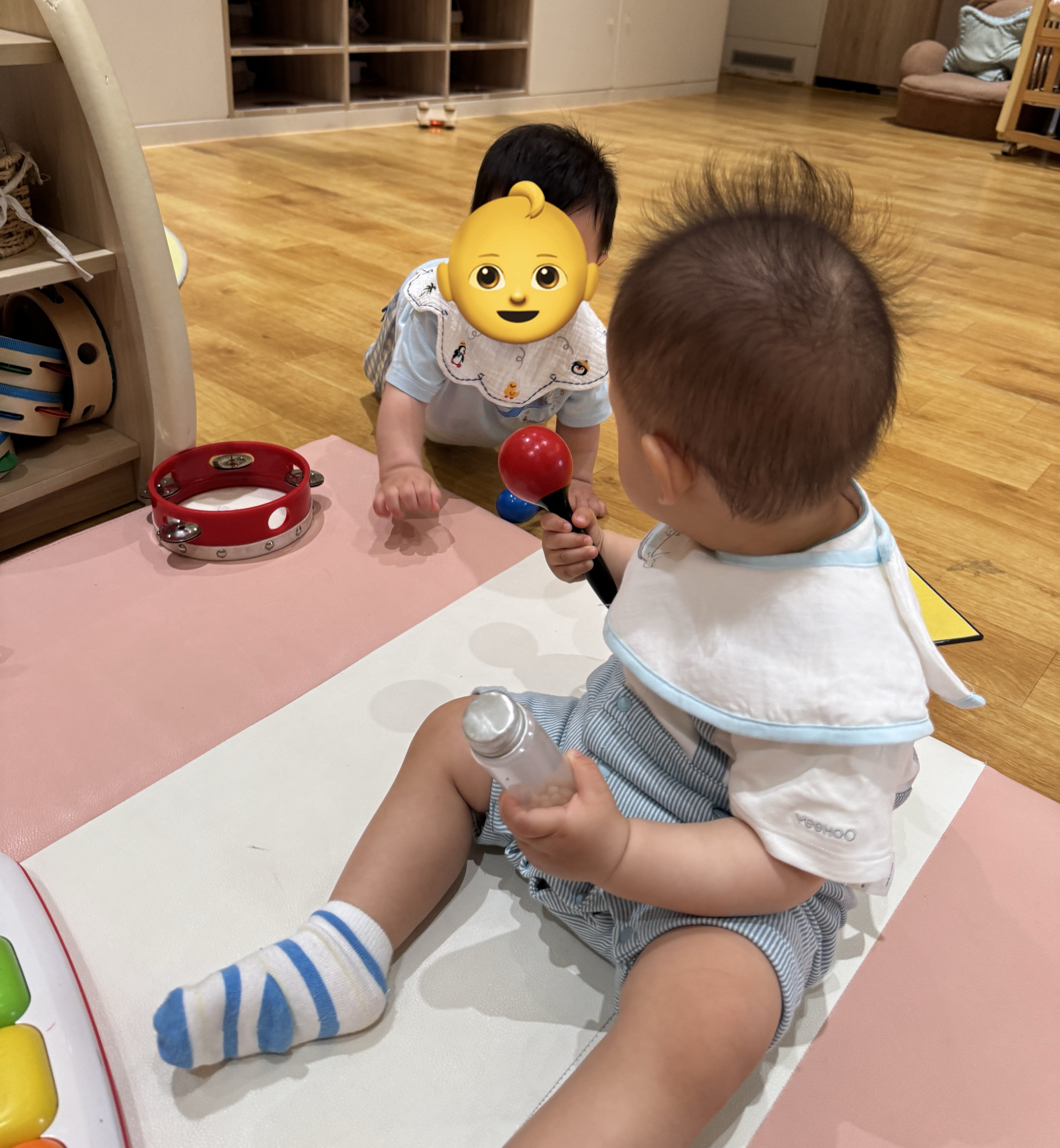 派派手握玩具，与同学友好交流